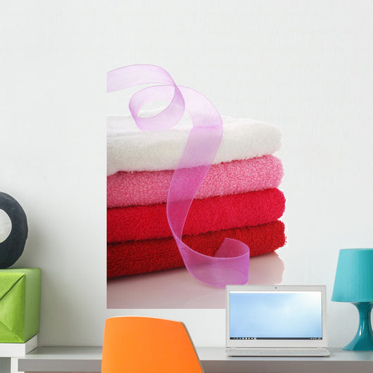 Stack of clean towels and pink ribbon Wall Mural