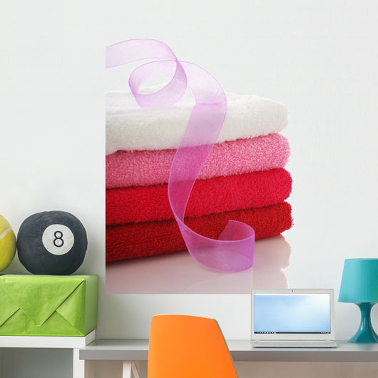 Stack of clean towels and pink ribbon Wall Mural