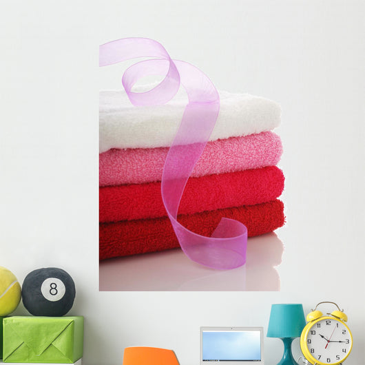Stack of clean towels and pink ribbon Wall Mural