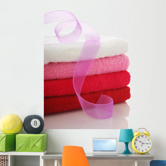 Stack of clean towels and pink ribbon Wall Mural
