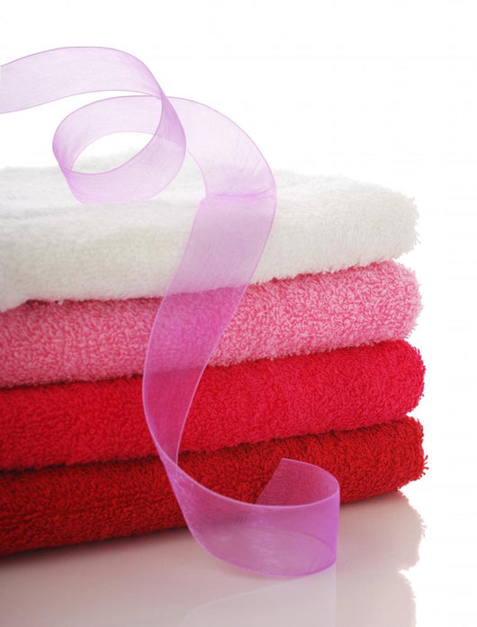 Stack of clean towels and pink ribbon Wall Mural