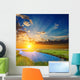 sunset over an green steppe and blue lake Wall Mural