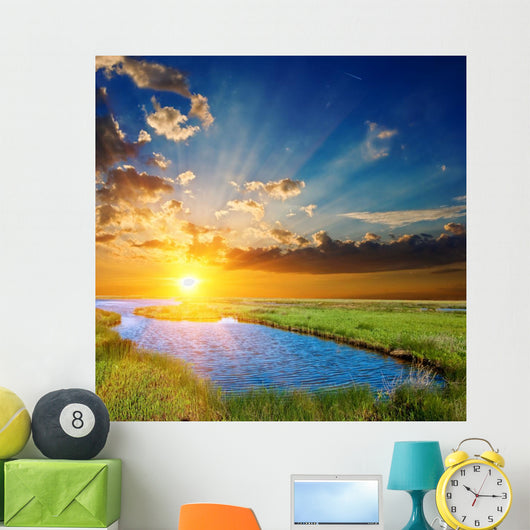 sunset over an green steppe and blue lake Wall Mural