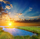 sunset over an green steppe and blue lake Wall Mural
