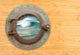 Antique Porthole With View of Crashing Waves Wall Mural