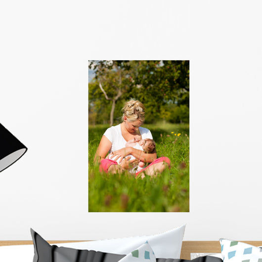 Mother nursing baby on meadow Wall Mural