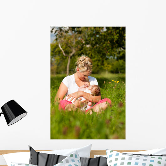 Mother nursing baby on meadow Wall Mural