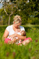 Mother nursing baby on meadow Wall Mural