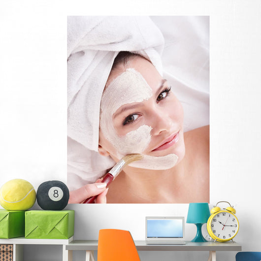 Girl with clay facial mask. Wall Mural
