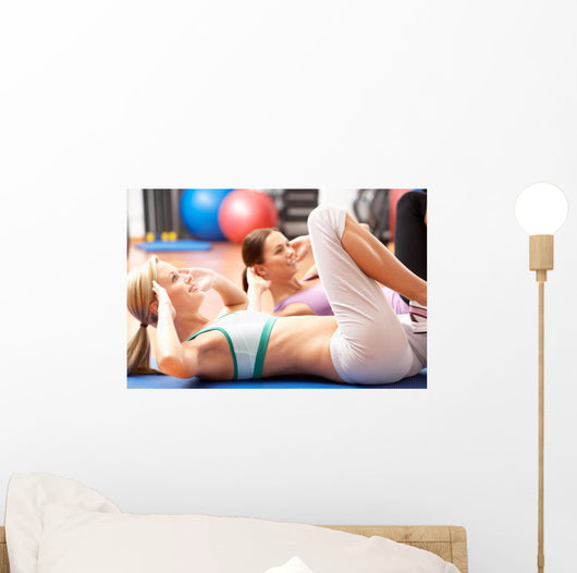 Women Doing Stretching Exercises In Gym Wall Mural