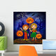 Boy and girl with pumpkins celebrates halloween. Wall Mural