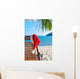 Red Santa's hat hanging on beach chair under palm tree Wall Mural
