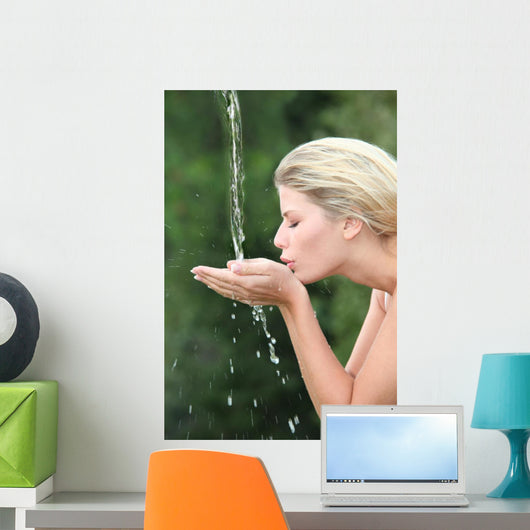 Blond woman drinking water from fountain Wall Mural