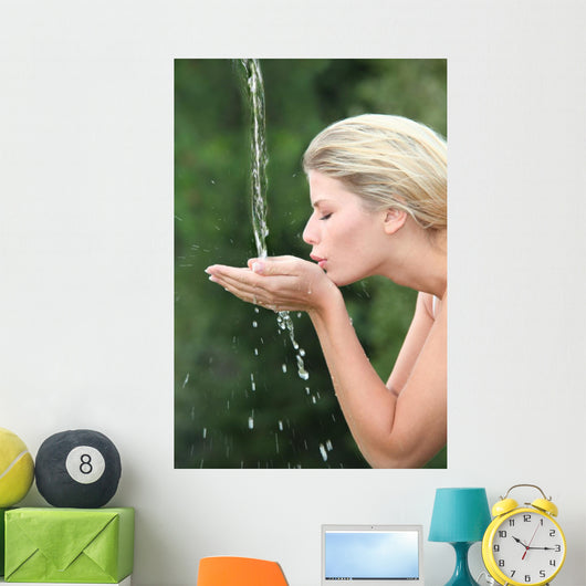 Blond woman drinking water from fountain Wall Mural