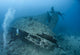 Scuba diver entering a shipwreck. Wall Mural