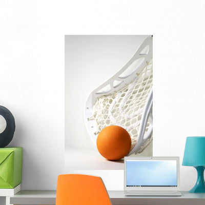 Orange Lacrosse Ball shown on a wall