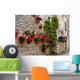 Colorful flowers lining a medieval stone wall in Italy Wall Mural