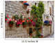 Colorful flowers lining a medieval stone wall in Italy Wall Mural