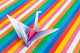An origami bird on a colorful stripes background. Wall Mural