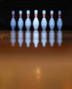 Old, battered bowling pins in dark background Wall Mural