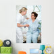 Nurse helps a patient to get up in hospital Wall Mural