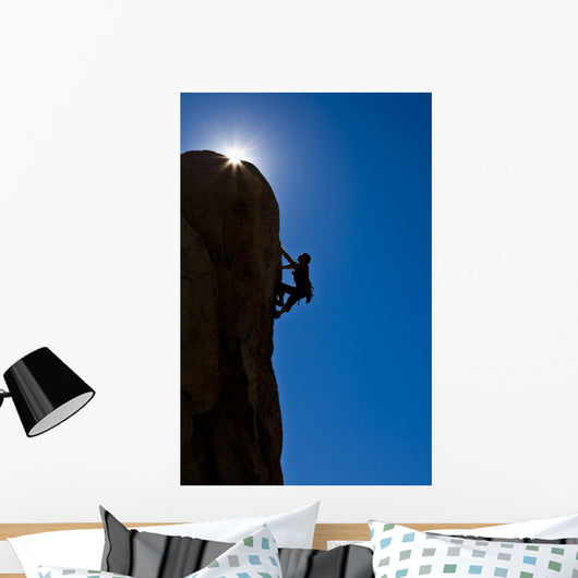 Rock climber clinging to a cliff. Wall Mural