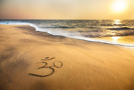 Om symbol on the beach Wall Mural