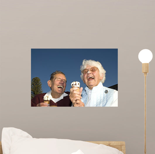 Elderly couple laughing at ice cream accident Wall Mural
