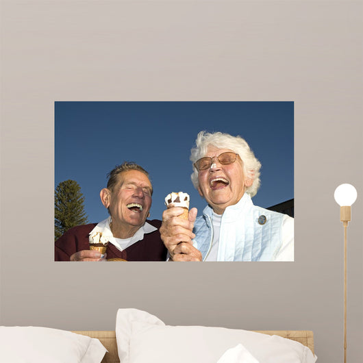 Elderly couple laughing at ice cream accident Wall Mural