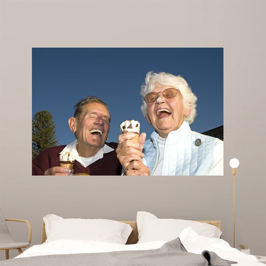 Elderly couple laughing at ice cream accident Wall Mural