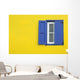 Colorful yellow house with blue shutters in Governor's Harbour Wall Mural