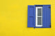 Colorful yellow house with blue shutters in Governor's Harbour Wall Mural