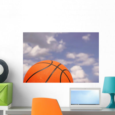 Orange Basketball against Cloudy Wall Mural shown on a wall