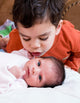 Young Boy Talking to His Newborn Sister Wall Mural