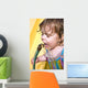 a toddler drinking water from a garden hose Wall Mural
