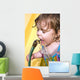 a toddler drinking water from a garden hose Wall Mural