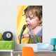 a toddler drinking water from a garden hose Wall Mural