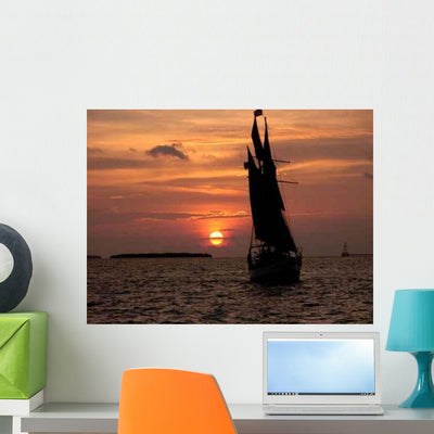 Orange Sunset with Sailboat Wall Decal shown on a wall