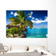 Tropical bungalow and palm tree next to amazing lagoon Wall Mural