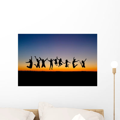 Silhouette Friends Jumping Sunset shown on a wall