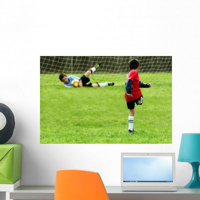 Boys Playing Soccer Wall Mural shown on a wall