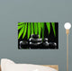 Spa stones and green palm leaf on black background Wall Mural