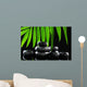 Spa stones and green palm leaf on black background Wall Mural