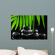 Spa stones and green palm leaf on black background Wall Mural