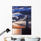 Lighthouse at sunset with light beam Wall Mural