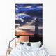 Lighthouse at sunset with light beam Wall Mural