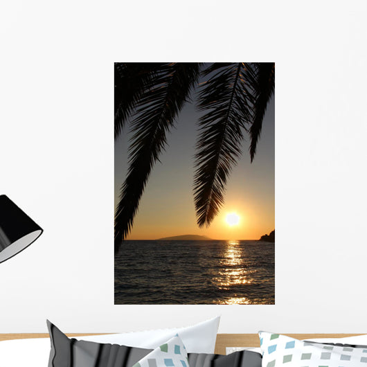 Palm leafs and sea in the evening, sunset Wall Mural