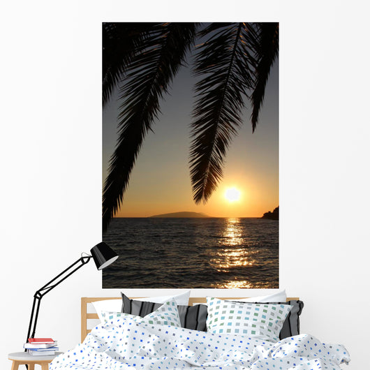 Palm leafs and sea in the evening, sunset Wall Mural