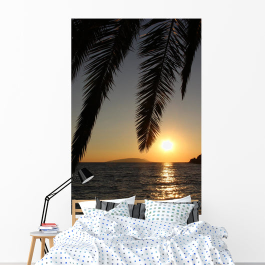 Palm leafs and sea in the evening, sunset Wall Mural