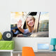Young woman waving from car window Wall Mural